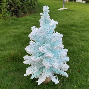 Détail d'un sapin de Noël bleu floqué avec des branches couvertes de neige