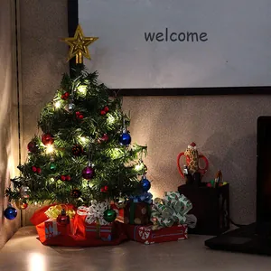 Decorated mini desktop Christmas tree featuring warm LED lights and colorful ornaments