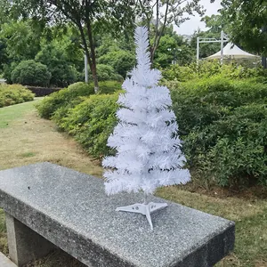 Detailed view of a small white Christmas tree displayed on a garden stone bench.