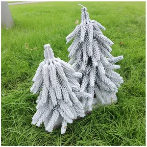 Detailansicht von zwei Mini-beschneiten PE-Zedern-Weihnachtsbäumen auf grünem Gras