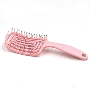 Close-up detail of the pink curved vented hair brush with smooth scalp massage pins.