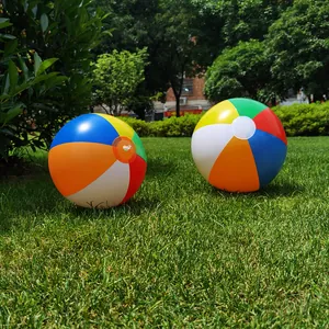 Pair of 35cm colorful inflatable beach balls with six-color panels on a green lawn