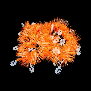 Detailed view of orange Halloween tinsel garland with white skull ornaments for party decor.