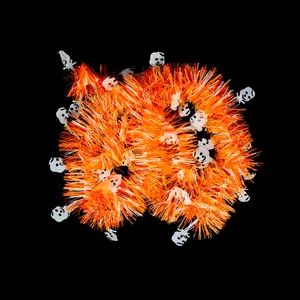 Detail view of orange Halloween tinsel garland featuring white skull ornaments