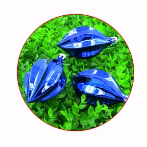 Primer plano de adornos navideños azules brillantes sobre fondo de follaje verde denso