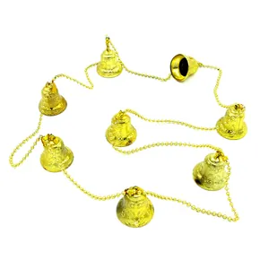 Close-up detail of a golden Christmas bell string featuring ornate embossed patterns