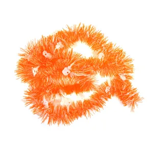 Close-up of orange Halloween tinsel garland featuring white skull decorations