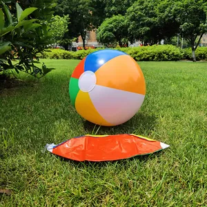 Detailed view showing the inflatable beach ball both inflated and deflated on grass.