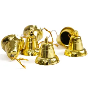 Nahaufnahme kleiner goldener Weihnachtsglocken mit Sternenmuster und goldener Schnur