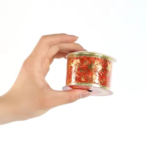Primo piano di un nastro natalizio rosso con stelle dorate stampate su un rotolo.