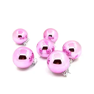 Detailansicht von sechs glänzenden rosa Weihnachtskugeln mit silbernen Aufhängern.