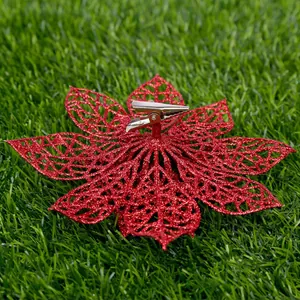 Close-up back view of red glitter Christmas flower showing metal alligator clip detail