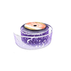 Dettaglio del nastro natalizio in organza viola con decorazioni stelle e lune