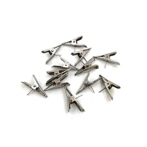 Detailed view of small silver metal alligator clips for DIY crafts and decorations.