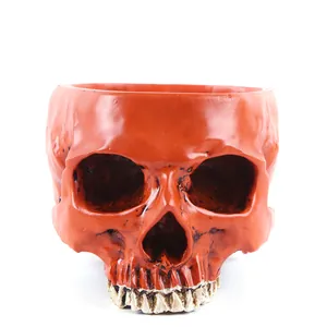 Detailed front view of an orange resin skull flower pot for Halloween home decor