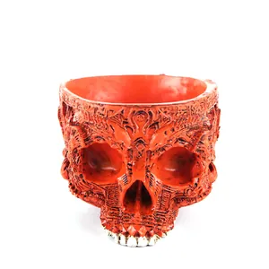 Detailed macro view of an intricate carved orange resin skull planter for Halloween decor.