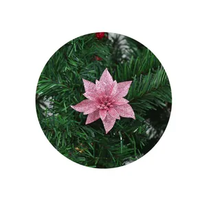 Nahaufnahme einer rosa glitzernden Kunstblume an einem grünen Weihnachtsbaumzweig