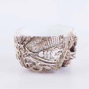 Close-up detail of a resin skull planter with intricate biomechanical carving texture.