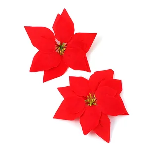 Detailed view of two red artificial poinsettia flowers for festive Christmas decoration.