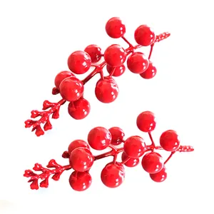 Gros plan de baies de Noël artificielles rouge vif avec finition brillante pour DIY