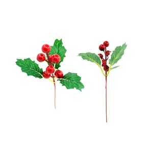 Detail shot of artificial red holly berries with green leaves for Christmas DIY crafts.
