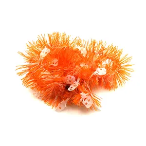 Macro detail view of orange Halloween tinsel garland featuring white skull decorations