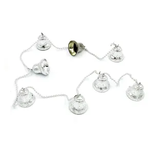 Detail view of silver Christmas bell garland string with ornate embossed floral patterns