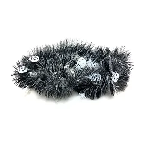 Macro detail of black Halloween tinsel garland featuring white skull motifs for festive decor