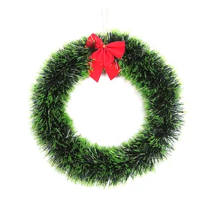 Detailed macro view of 30cm green tinsel Christmas wreath with a bright red bow