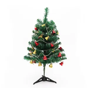 Detailed macro view of artificial green Christmas tree with red and gold bell ornaments