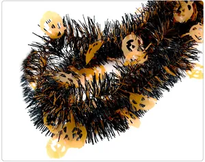 Detail of Halloween tinsel garland with orange pumpkin cutouts and black metallic fringe.
