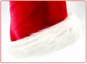 Nahaufnahme des weichen weißen Plüschbesatzes und des roten Samts einer klassischen Weihnachtsmütze