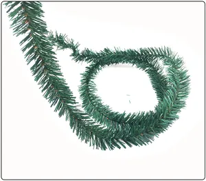 Macro detail showing the dense green pine needle texture of the flexible Christmas garland.