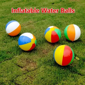 Detailed view of multiple colorful inflatable beach balls scattered on green grass