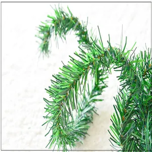 Macro detail of a 5.5m green Christmas tinsel garland showing artificial pine textures.