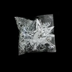 Close-up of silver reindeer ornament and shiny tinsel packed in clear plastic bag