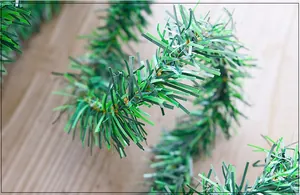 Detailed close-up showing the texture of a 5.5m green Christmas tinsel garland vine