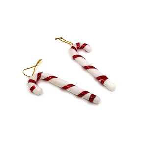 Zwei klassische rot-weiße Weihnachts-Zuckerstangen-Anhänger mit goldenen Schnüren.