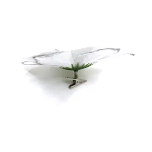 Detail view of the metal crocodile clip attachment on a white artificial flower.