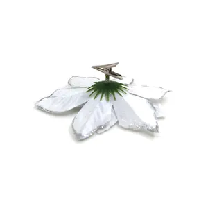 Detailed view of a silver alligator clip attached to the back of a white deco flower.