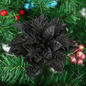 Detaillierte Ansicht einer schwarzen Glitzerblume an einem grünen Tannenbaumzweig