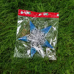 Détail d'une étoile de sapin de Noël ajourée bleue et argentée dans son emballage