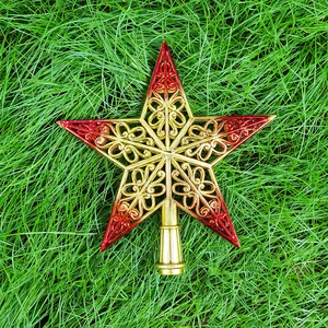 Vue détaillée de l'étoile filigrane dorée et rouge pour le sommet du sapin de Noël