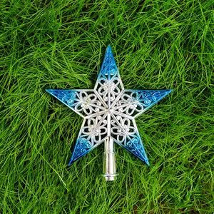 Étoile creuse élégante pour sapin de Noël avec dégradé bleu et argent posée sur l'herbe