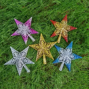 Vue détaillée de cinq cimiers de sapin de Noël en forme d'étoiles filigranes colorées sur herbe