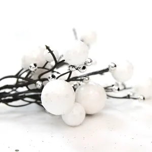 Gedetailleerde close-up van witte sneeuwbessen en zilveren kralen op decoratieve kersttakken