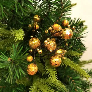 Gedetailleerd beeld van gouden glitter bessenstelen op een groene kerstboom