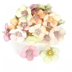 Dettaglio di mini teste di margherite artificiali da 2cm in vari colori pastello tenui