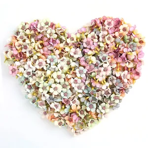 Dettaglio di mini margherite in seta colorate da 2 cm disposte a forma di cuore