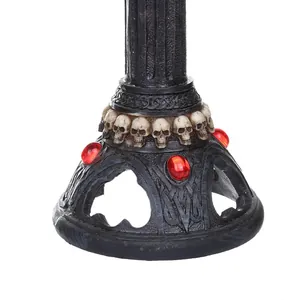 Primer plano detallado de base de candelabro gótico de resina con calaveras y gemas